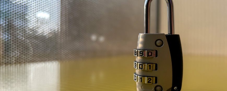 Lock-on-a-yellow-desk-with-tinted-glass-window-behind